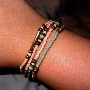 Stretchy pink, gold and green beaded bracelet set.